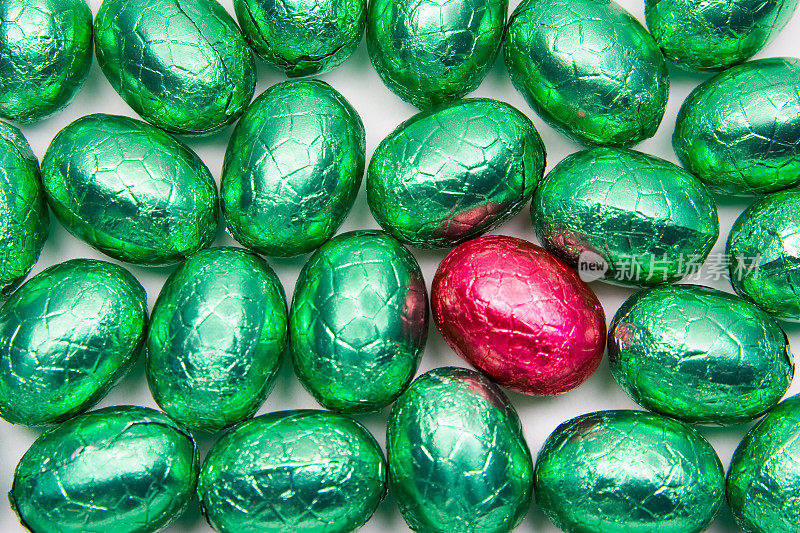 许多绿色和一个红色的复活节彩蛋在白色的上面