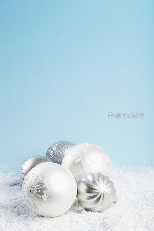 雪蓝色背景上的银色圣诞装饰物