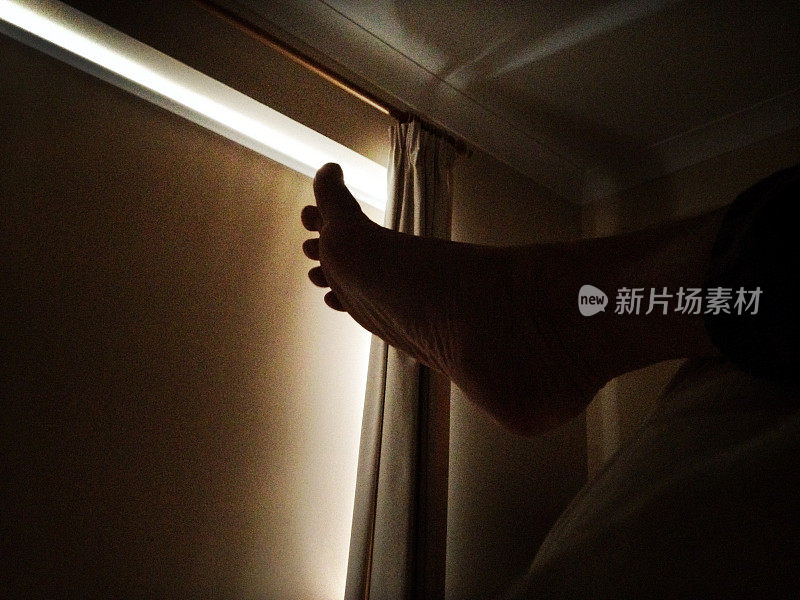 在黑暗的卧室里，放松的脚在床上