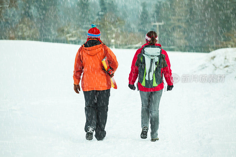 两个女性朋友在雪天徒步旅行