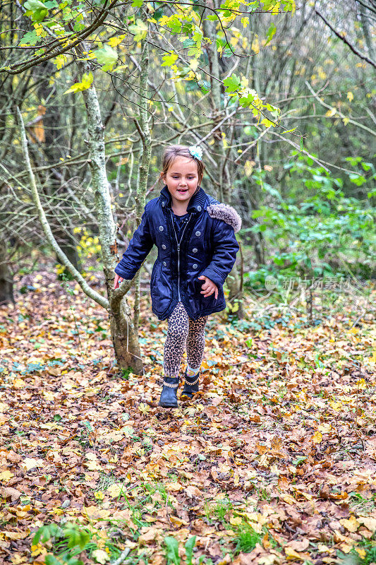 一个七岁的小女孩在树林里奔跑