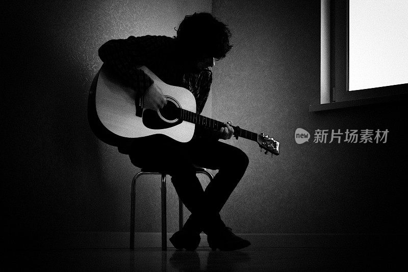 一名男子弹吉他的黑白照片