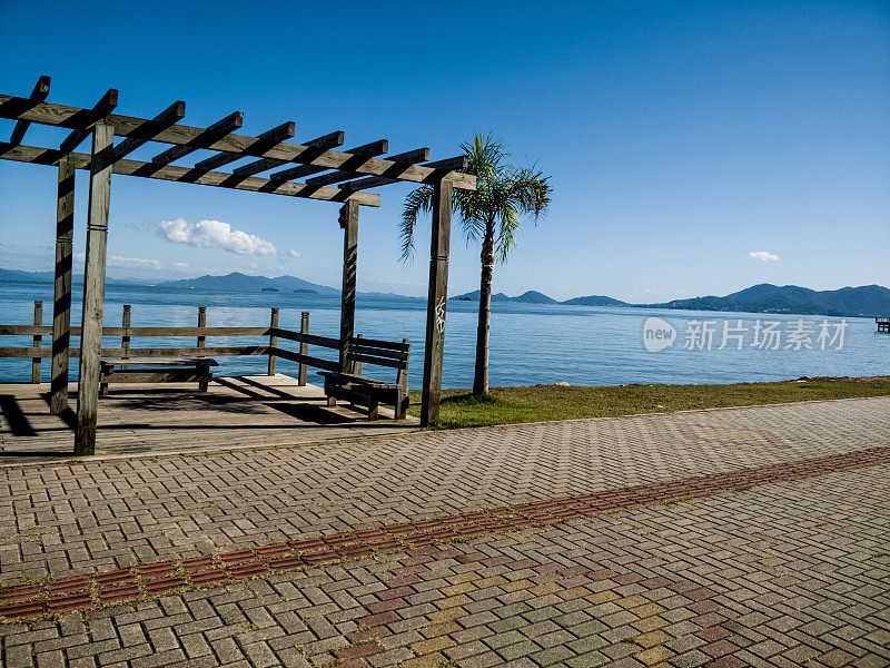 边境上有椰子树和FLorianópolis的木板路，可以看到大海