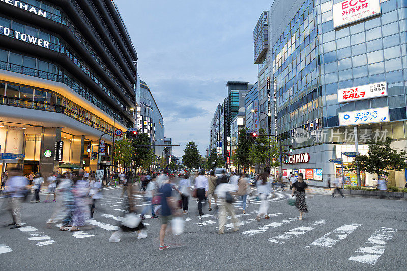 黄昏时分，日本京都的一群人穿过马路