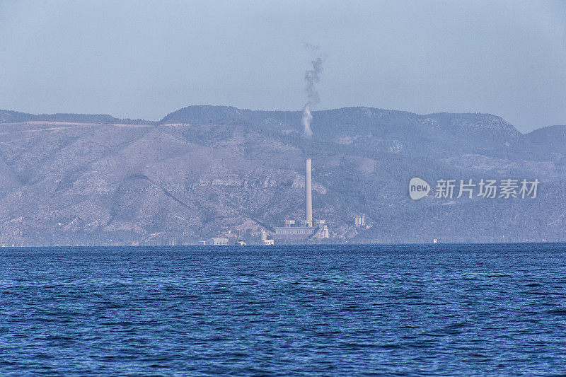 位于土耳其博德鲁姆附近的戈科娃湾的爱琴海海岸，带有冒烟烟囱的燃煤火电厂