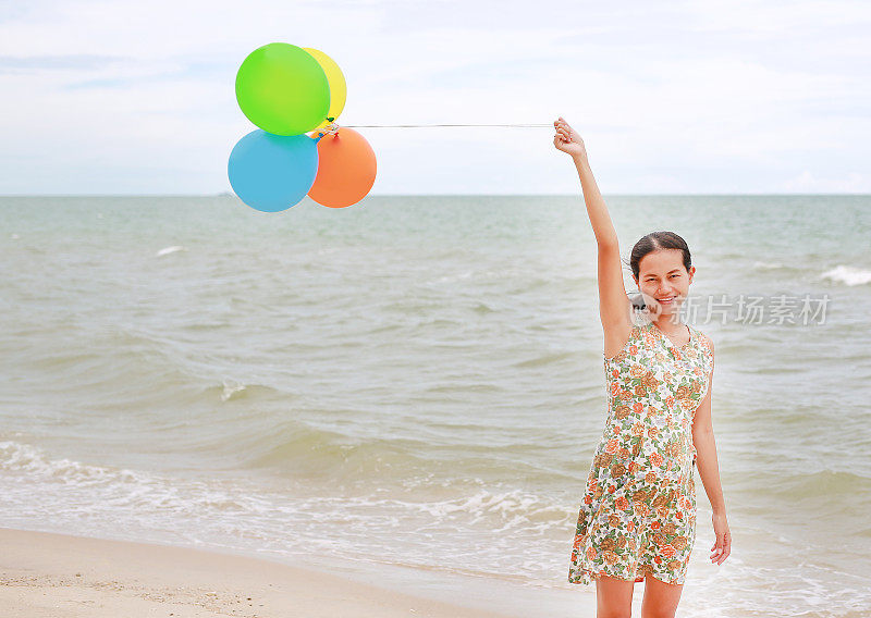 快乐女人的肖像在海滩上玩气球度假。节日的概念。