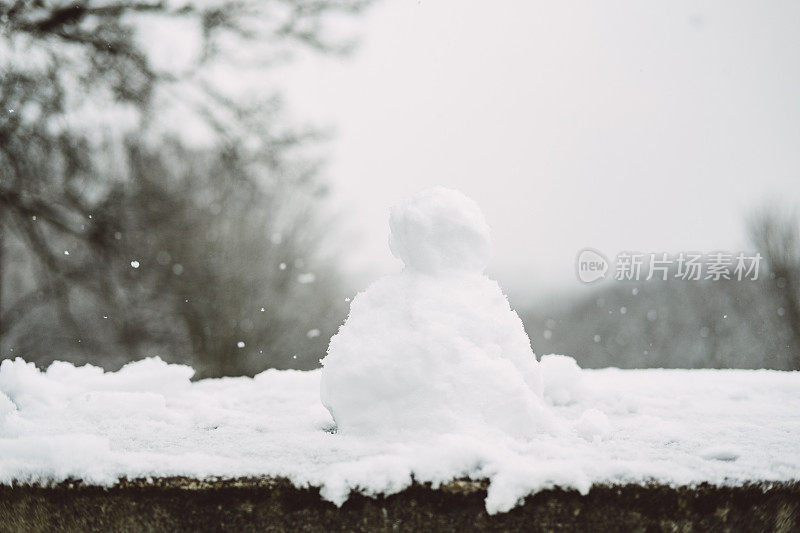 在一个下雪的冬天，墙上的迷你雪人。