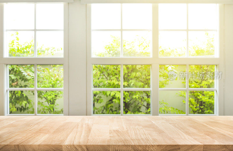 顶部的木桌子柜台上模糊的窗口查看花园背景。