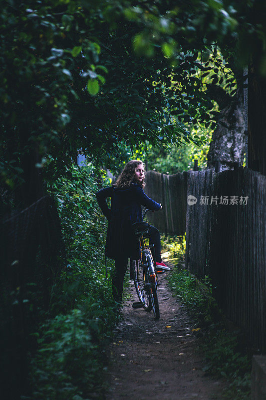 在绿色隧道里骑着旧自行车的少年
