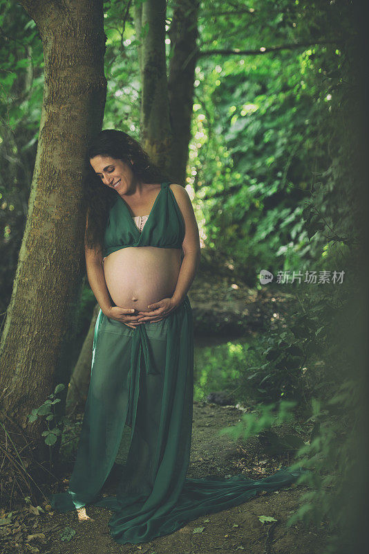 一个女人对她的怀孕很兴奋，等不及要见她的孩子了。