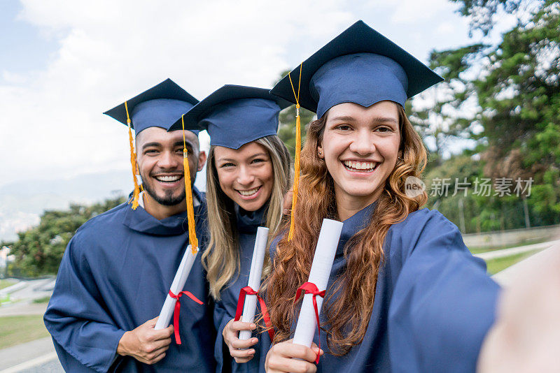 一群从大学毕业的年轻朋友在自拍，都看着相机很兴奋