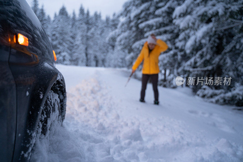 第一场雪后打扫汽车和扫地。紧急照明设备。在恶劣的天气下，汽车会在偏僻的地方抛锚。汽车保险。一个女人在路上。