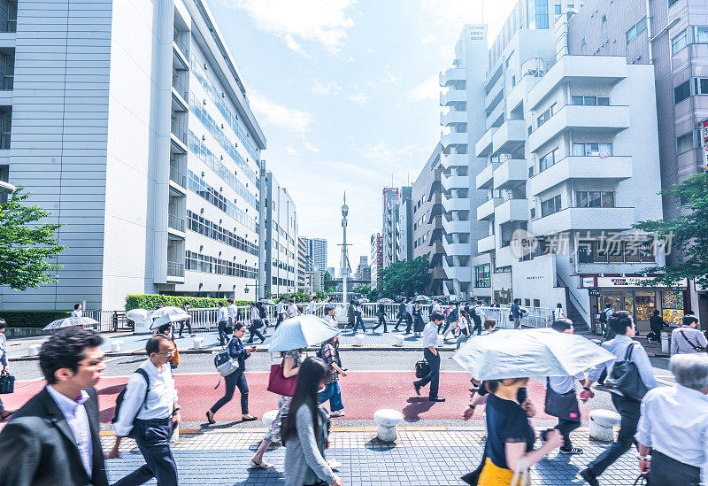 在日本东京早高峰时段，企业和办公室的工作人员正匆忙地去上班
