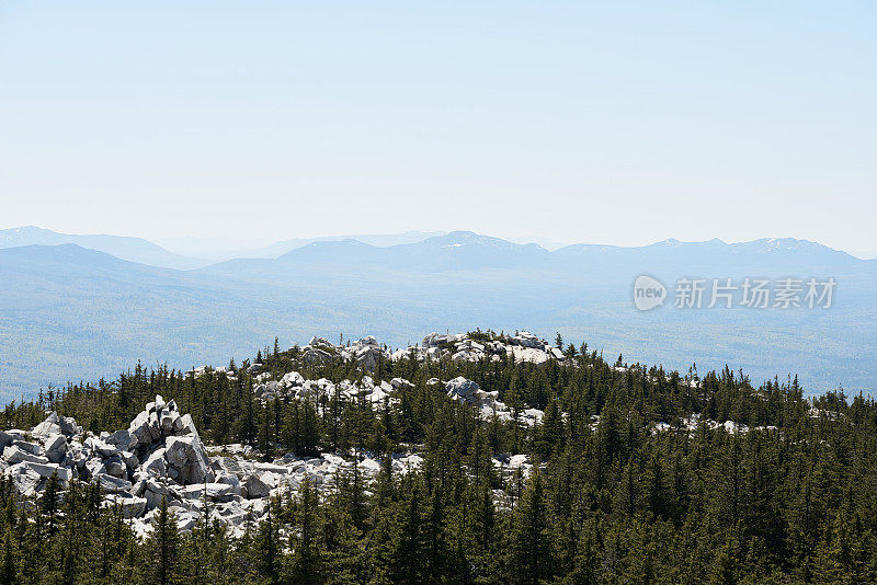 鸟瞰图广阔的针叶林，巨大的白色岩石和高山在远处。国家公园，乌拉尔地区，俄罗斯