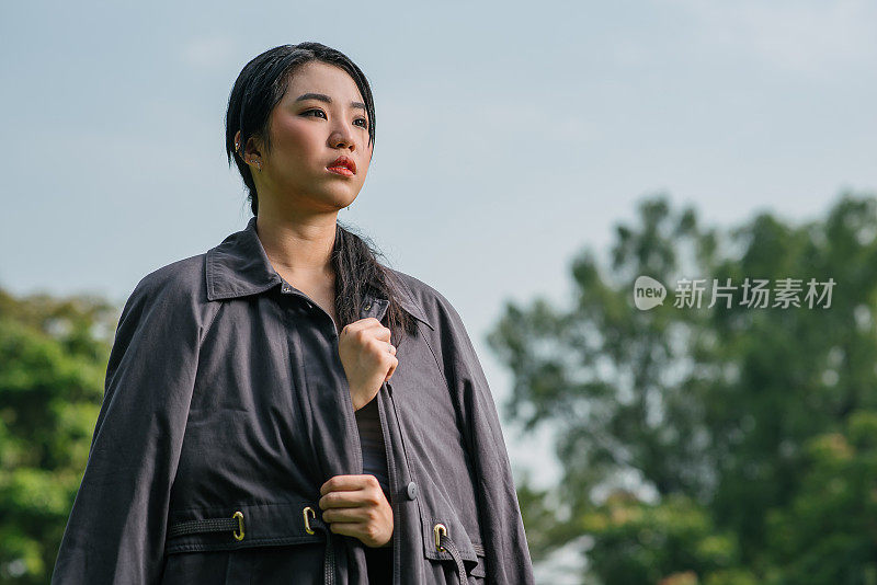 亚洲华裔少女女模特站在公园以冷静的态度