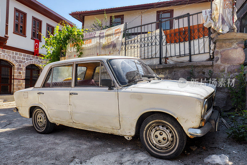在土耳其安卡拉的哈莫努区贫民区，一辆停在棚户区前的老式报废菲亚特124汽车