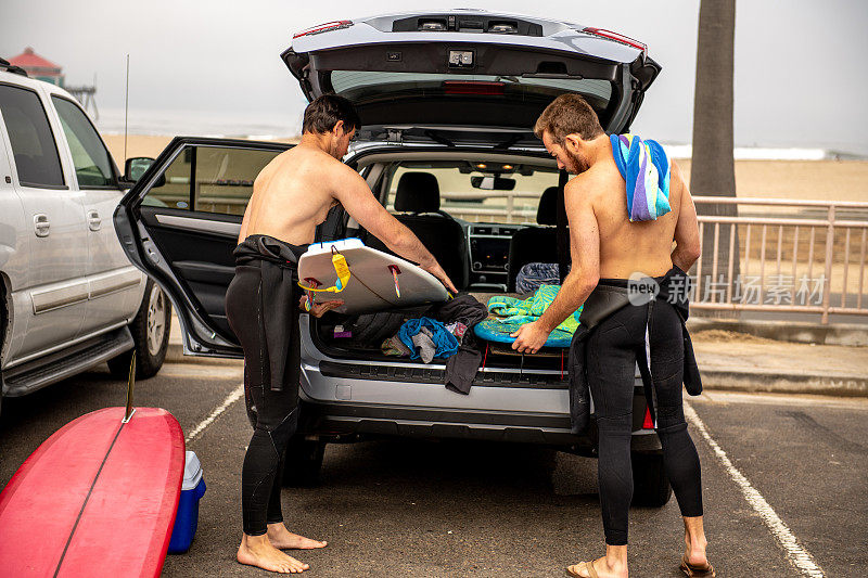 两个冲浪者从车上卸下冲浪板