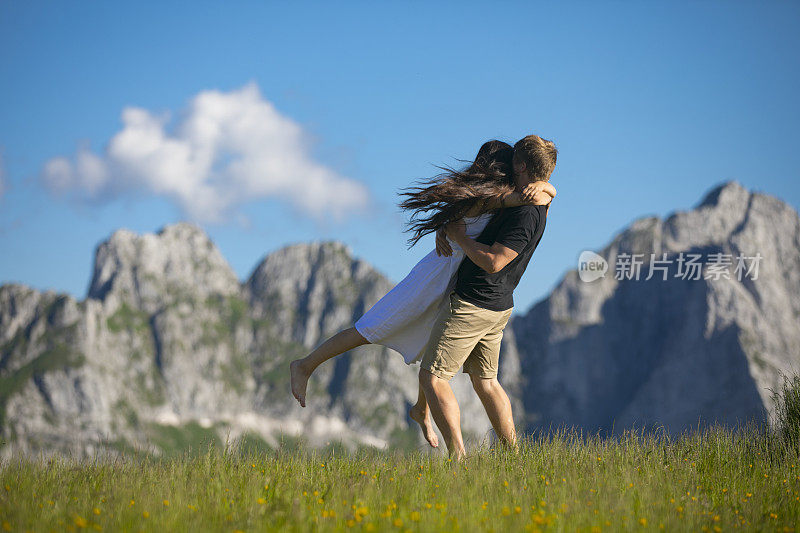 年轻夫妇在田园诗般的山景结合