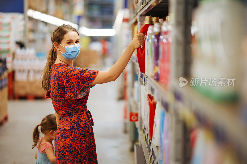 带着女儿戴着防护面具购物的女人