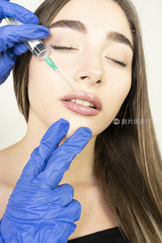 年轻女子在嘴唇上注射肉毒杆菌。在美容院的女人。整形外科诊所