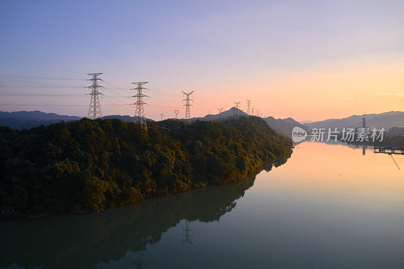 日落时分，一座高压电塔矗立在中国浙江省的一座湖边山上
