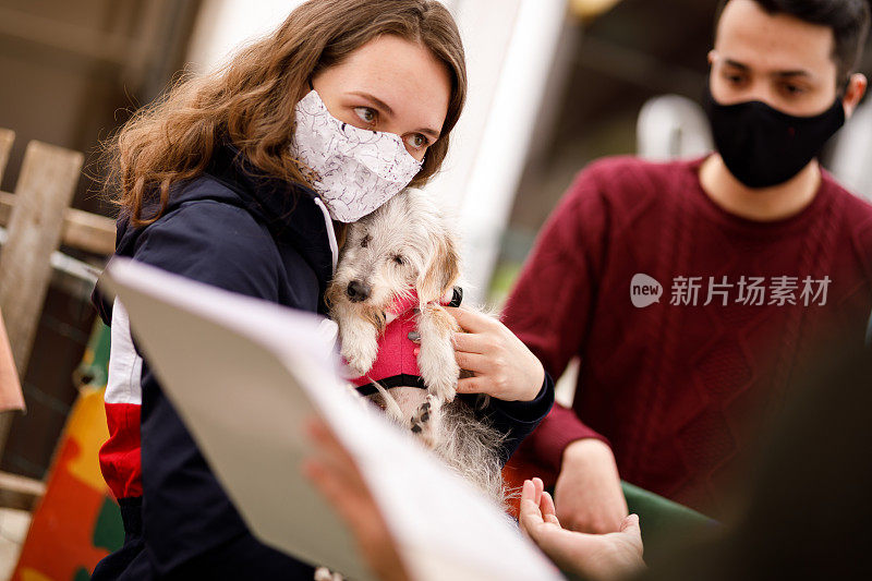 在宠物收养活动上，一个女人拥抱一只狗