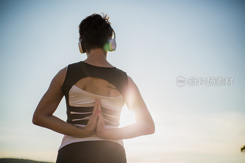 一个年轻美丽的女人在日落时做瑜伽。生活方式，放松，情感概念，冒险，暑假，与自然和谐。