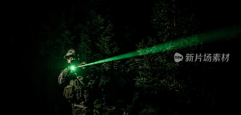 夜间军事特殊行动操作员在行动与绿色激光瞄准近摄像机