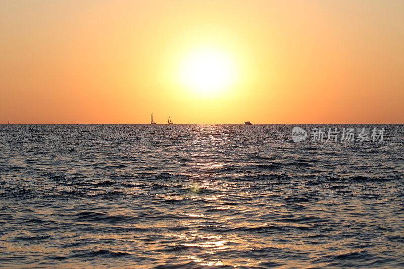 海上日落游艇快艇剪影涟漪的波浪图案金色的小时阳光夏天抽象的反射发光的海蓝色金色橙色粉红色红色黄色波浪的散景背景彩色的海景太阳天空地平线黄昏到夜晚时间流逝旅行复制空间