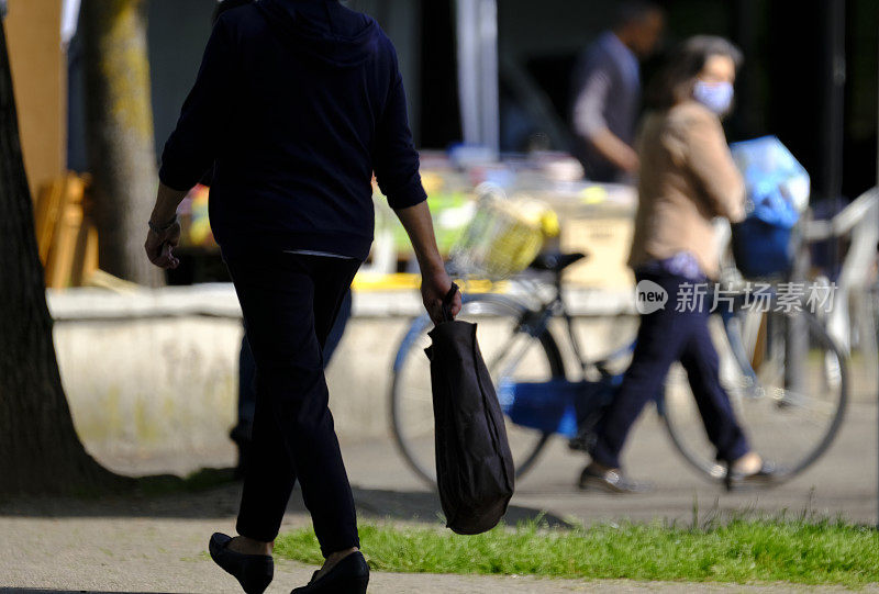 人们在一个阳光明媚的日子里走在街上