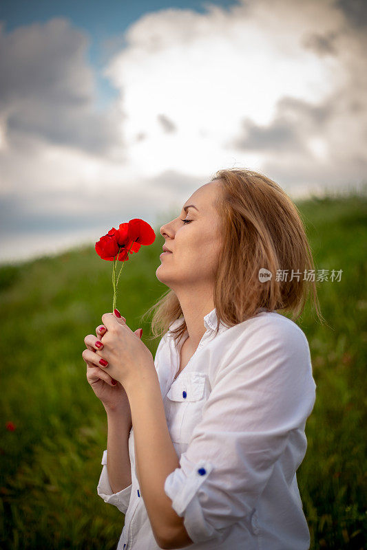 女人拿着罂粟，普通的罂粟，红色的花