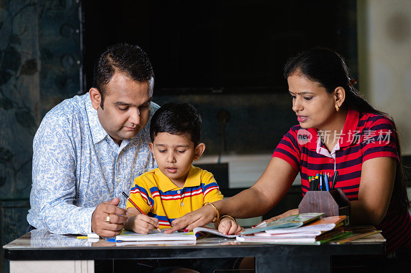 父母在家里帮助儿子学习和完成家庭作业。
