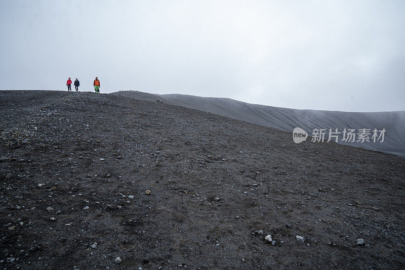 在冰岛北部的赫弗尔火山口上徒步旅行的游客。