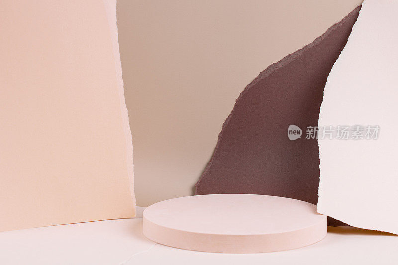 创意构图:空的圆形讲台平台用于产品展示，曲线形状的撕裂的牛皮纸边缘在柔和的米色背景上。前视图