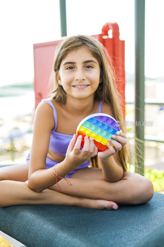 美丽的女孩享受抗压力彩虹流行它在海滩烦躁