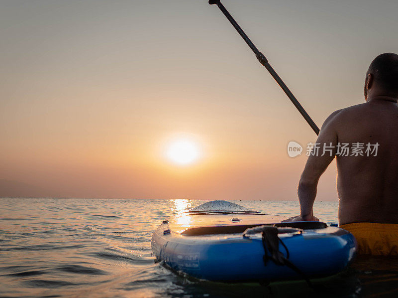 日落时男子划桨的剪影