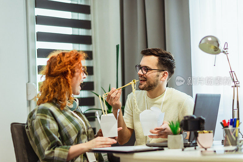 一对在家工作的夫妇吃着网上订购的中餐。