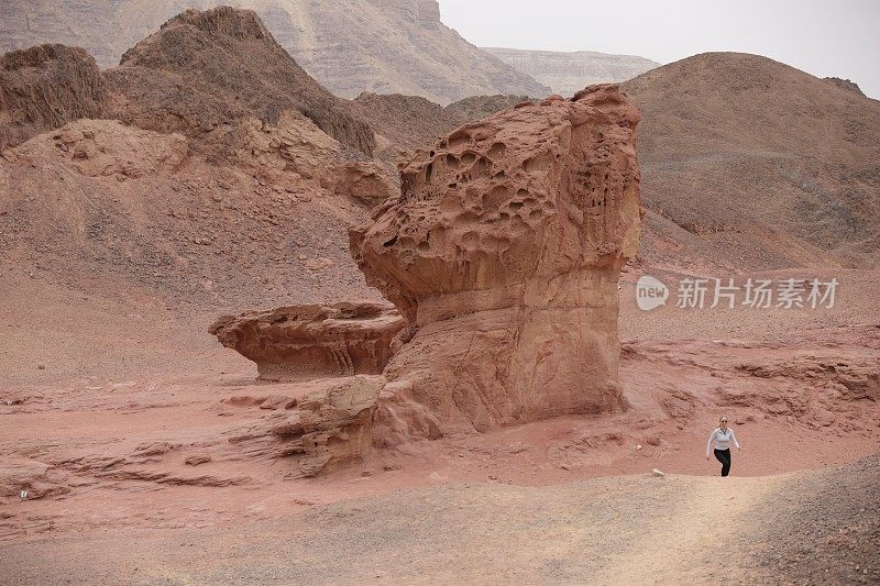 沙漠中行走在山石之间的女人