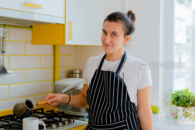 在厨房煮咖啡的女人。概念快乐晨间休闲