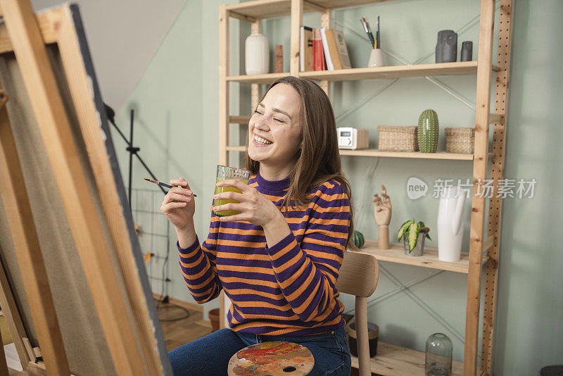 一位美丽的年轻女子在家享受绘画的肖像