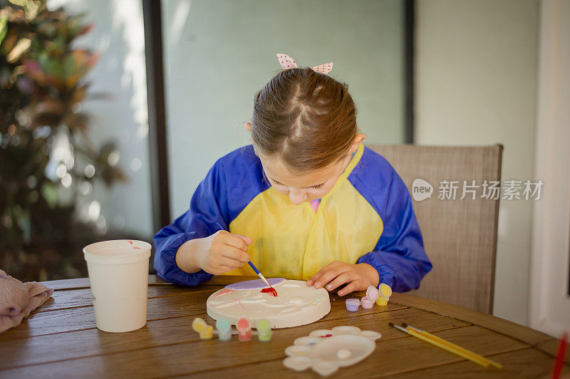 年轻的女孩正在画一个踏脚石工艺美术项目