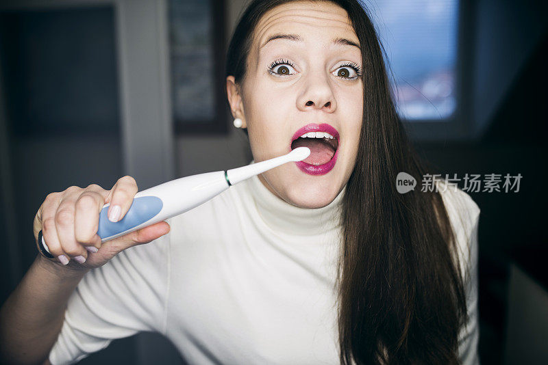 快乐女人使用电动牙刷