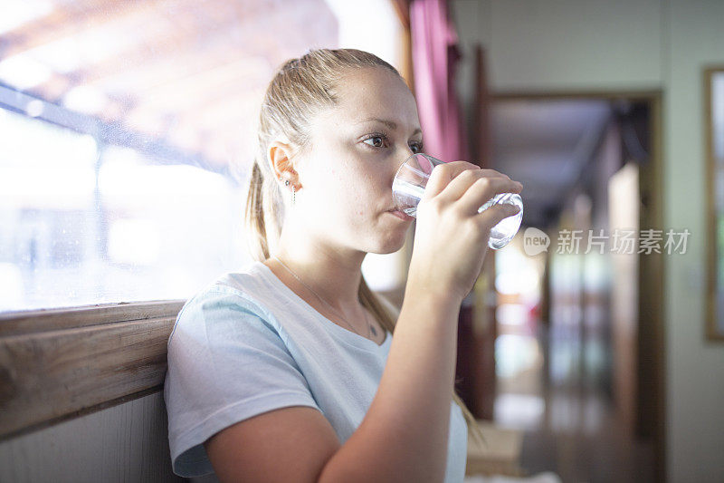 一个喉咙痛的女人喝水的肖像