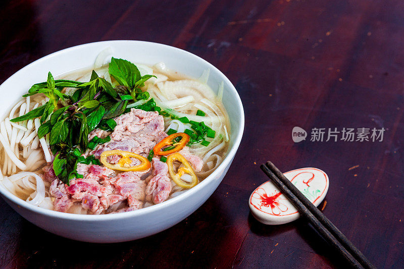 越南河粉汤，牛肉和米粉放在桌子上，特写。越南当地的餐馆。