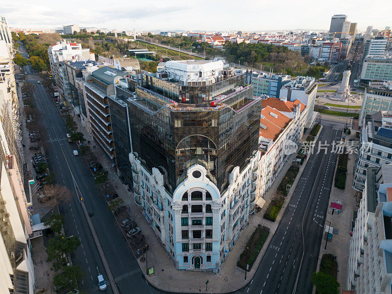 白天城市附近的航拍图像，里斯本的蓬巴尔马奎斯广场位于建筑物和街道中间