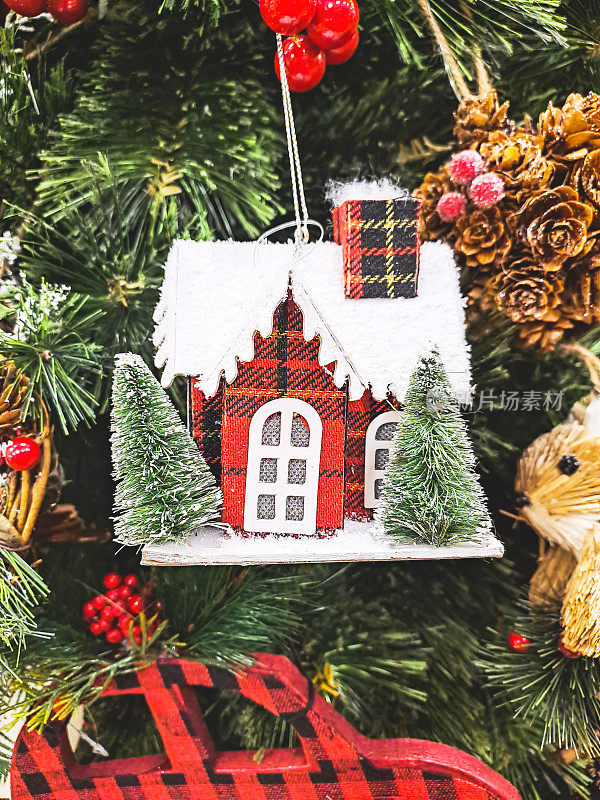 圣诞树挂饰。有雪的圣诞屋。挂在树上的圣诞屋装饰品。