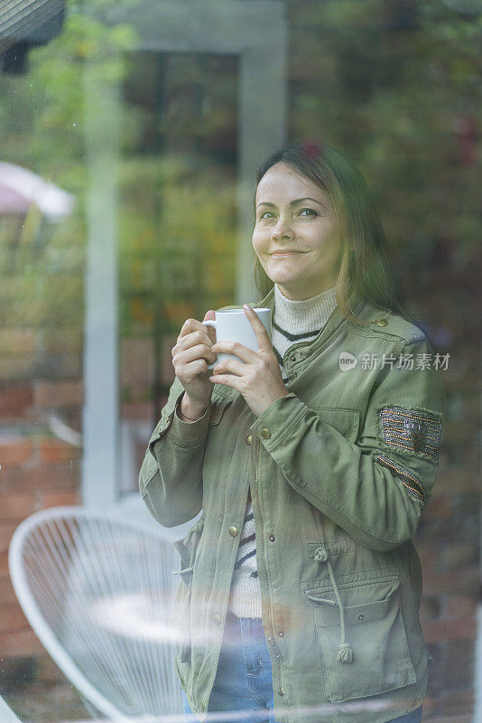 治疗师一边享受着她的咖啡，一边看着窗外