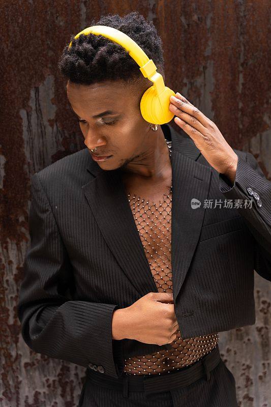 一个黑人男子用无线黄色耳机听音乐的特写