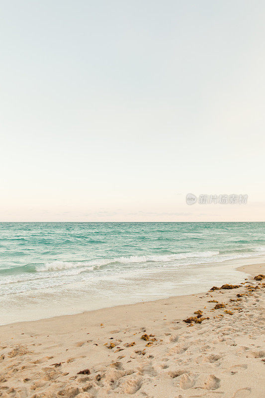 柔和的日落天空在蓝绿色棕榈海滩，佛罗里达州海岸线日落在2023年冬天