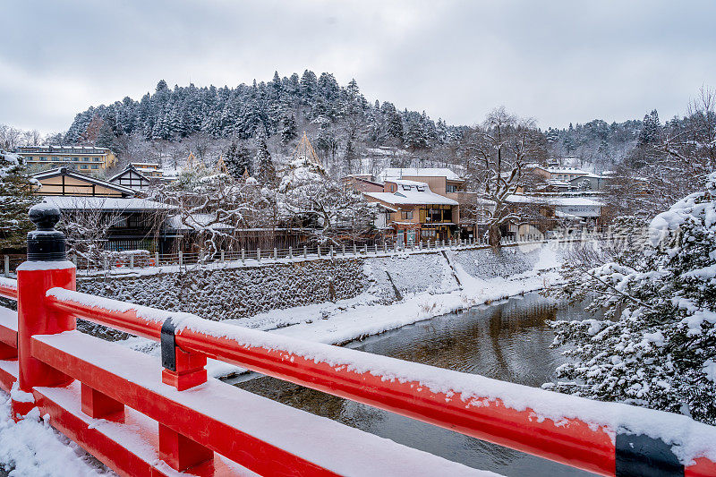 高山村雪与红色木桥和溪水，日本